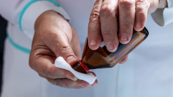 rubbing alcohol being applied to cotton pads